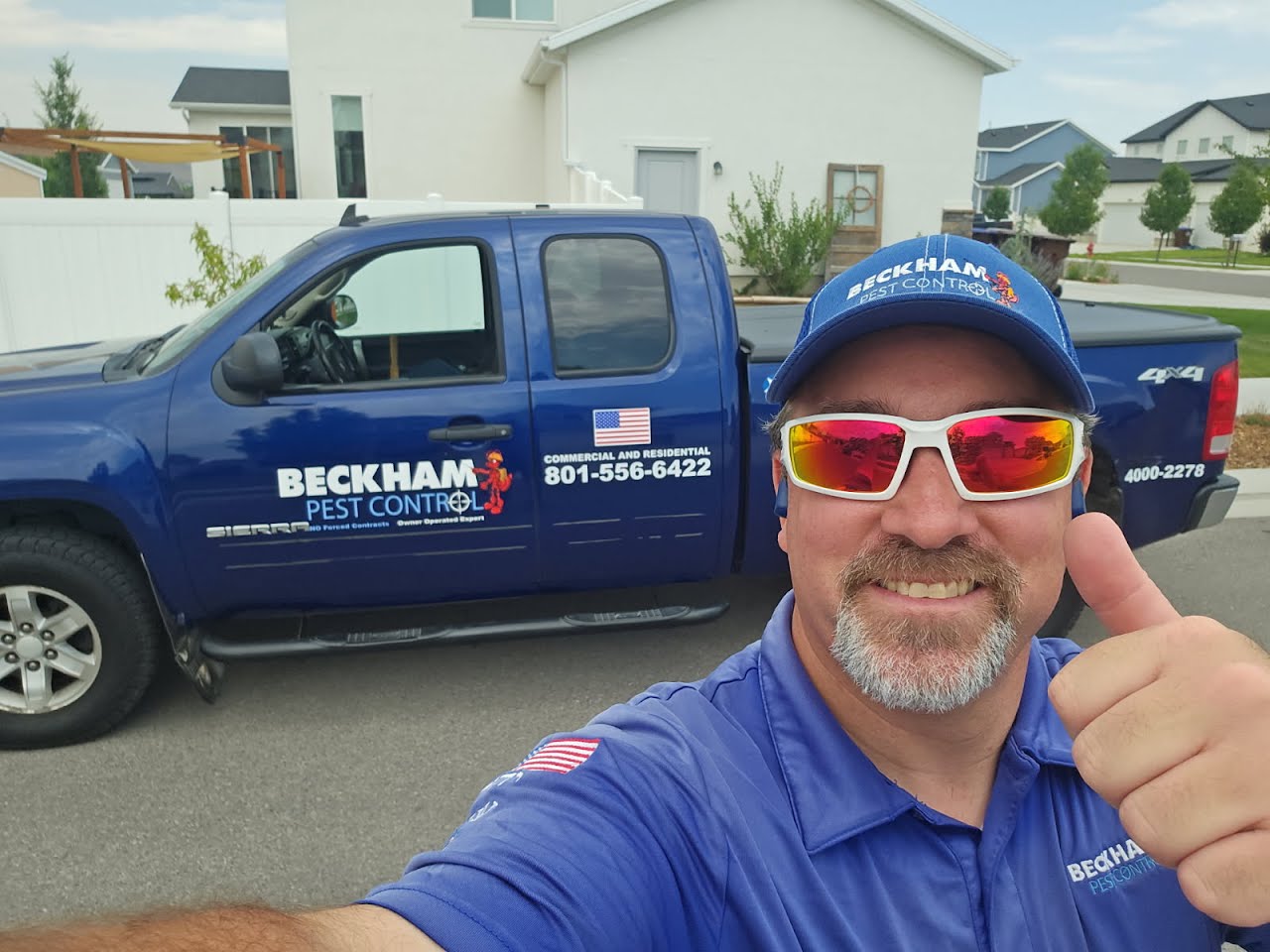 Orion Beckham in a Beckham Pest Control cap and blue shirt, thumbs up, in front of the navy truck. The cab shows 801-556-6422.